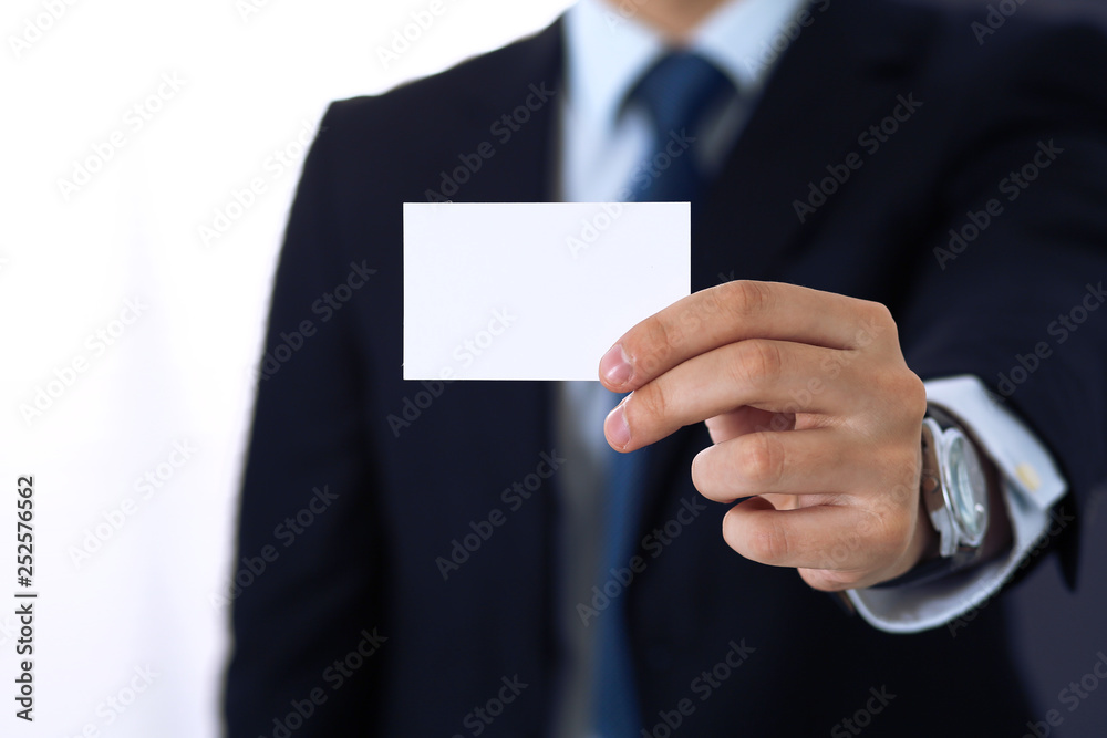 Unknown businessman hand holding business card with empty space, close-up Unknown businessman hand holding business card with empty space, close-up
