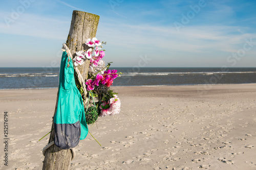 Pfosten mit Kunstblumen- Geheimnis am Strand von Norderney