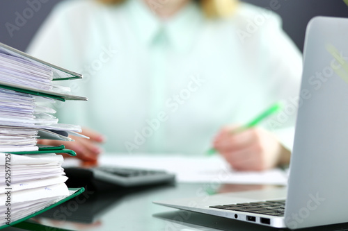 Bookkeeper or financial inspector making report, calculating or checking balance. Audit and tax service concept. Green colored image background 