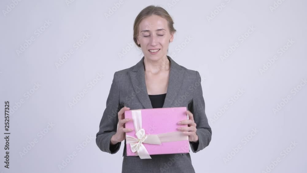 Happy young blonde businesswoman thinking while holding gift box Happy young blonde businesswoman thinking while holding gift box