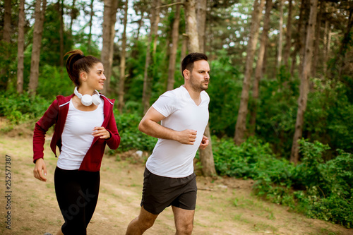 Healthy fit and sportive couple running in nature