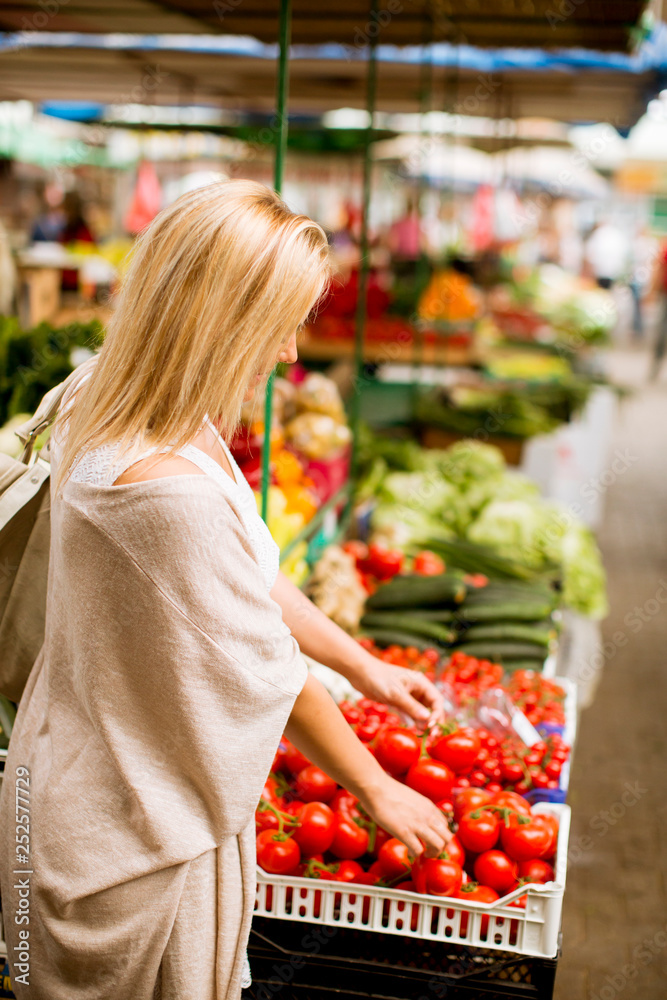 Cute young woman buying vegetables at the market Cute young woman buying vegetables at the market