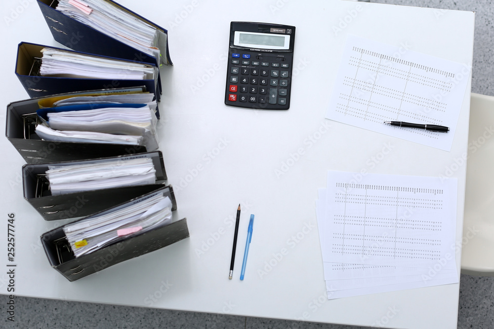 Binders with papers are waiting to be processed with bookkeeper. Internal Revenue Service inspector working place. View from above Binders with papers are waiting to be processed with bookkeeper. Internal Revenue Service inspector working place. View from above
