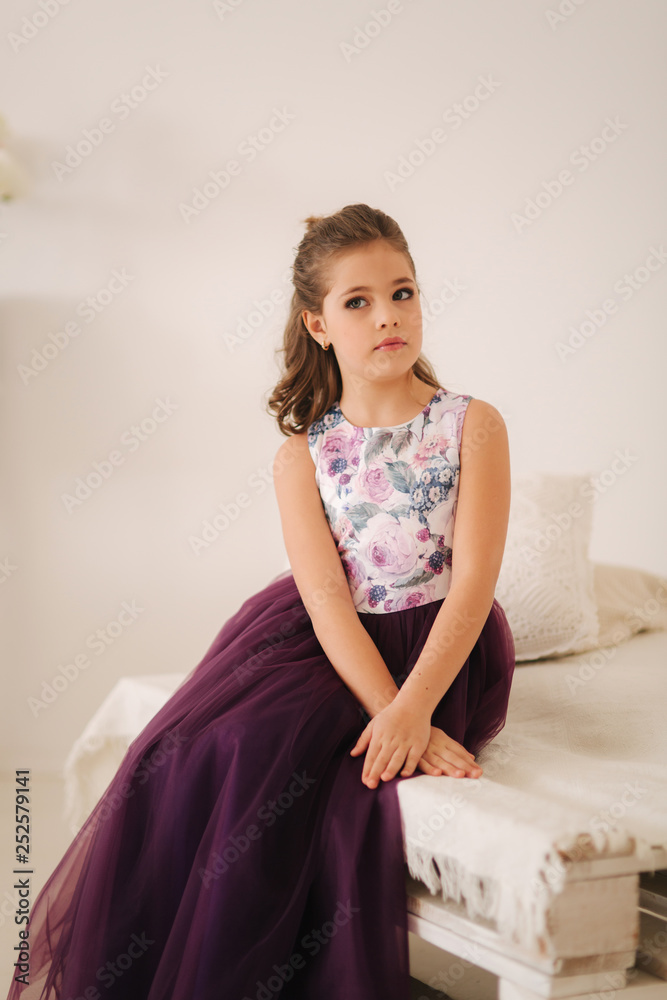 Beautiful girl in a purple dress and flower blouse posing for a photographer Beautiful girl in a purple dress and flower blouse posing for a photographer