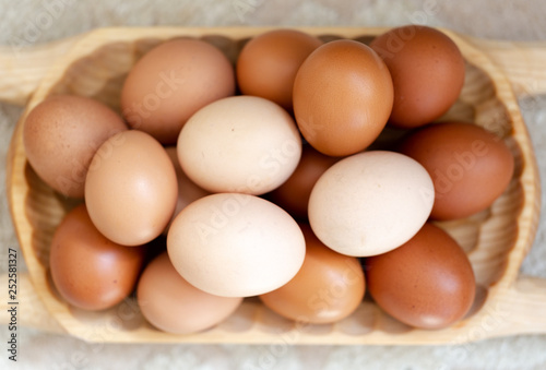 Plain multicoloured free range eggs on wooden plate