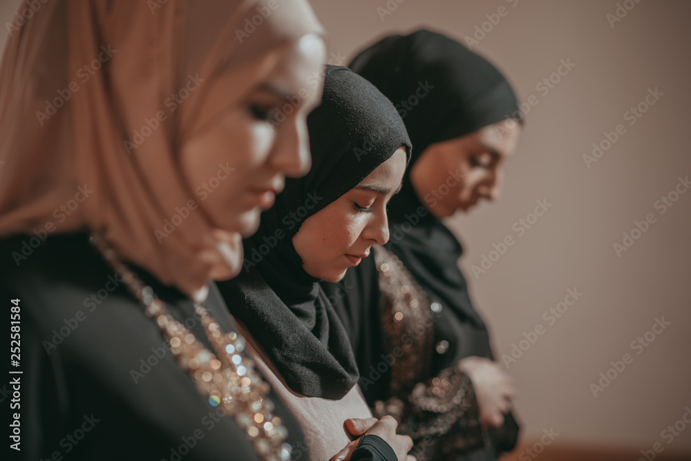 Three muslim girls pray together in mosque Three muslim girls pray together in mosque
