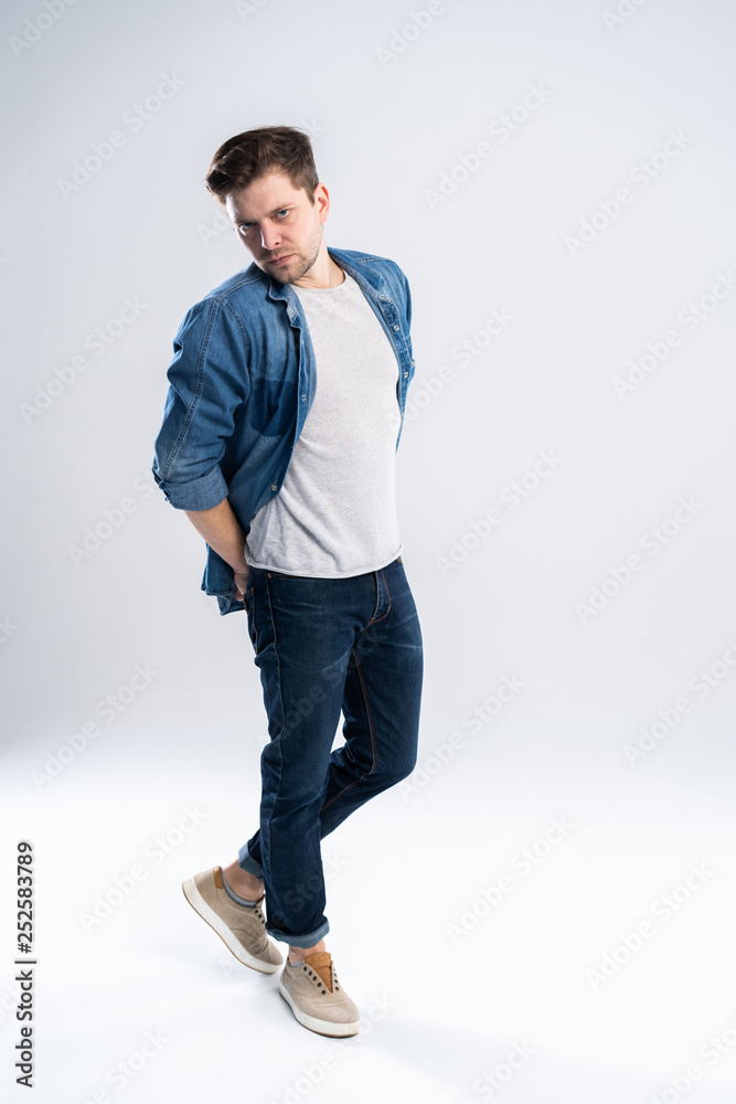 Naklejka premium Full length portrait of a casual man standing over white background.