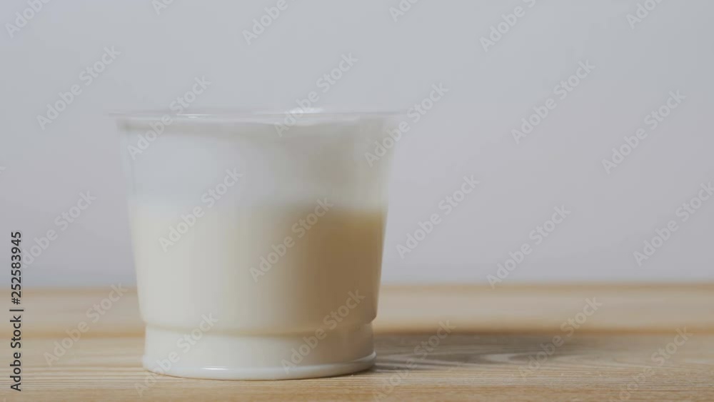 The girl eats yogurt from a jar. The girl eats yogurt from a jar.