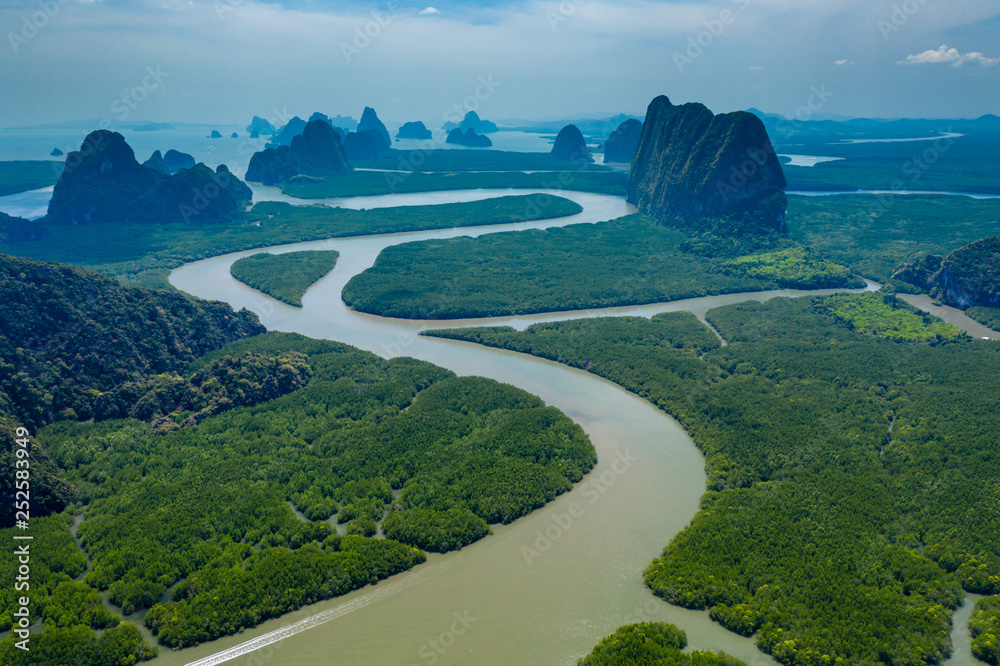 Aerial drone view of towering limestone cliffs and mangrove forest in Phang Nga Bay, Thailand