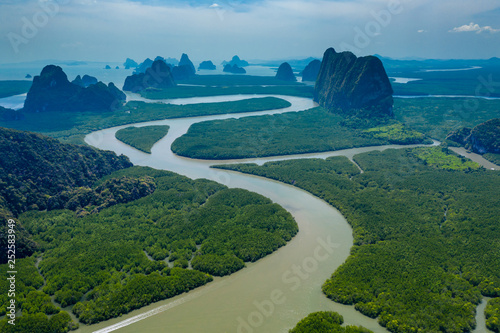 Aerial drone view of towering limestone cliffs and mangrove forest in Phang Nga Bay, Thailand