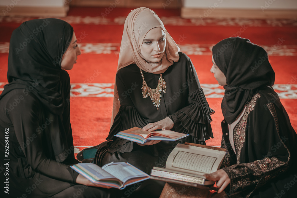 Three muslim girls reading Quran in mosque Three muslim girls reading Quran in mosque