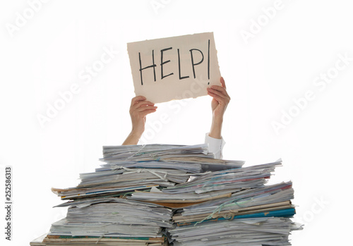 Person under a pile of papers with a hand holding a sign of help. Accounting.