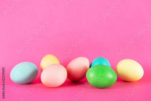 Canvas Print Bunch of blank painted Easter eggs of different pastel color isolated on bright pink background with a lot of copy space for text