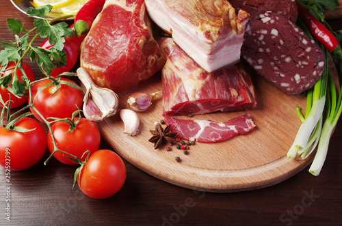 Fototapeta Naklejka Na Ścianę i Meble -  Meat products and vegetables. Ham and sausage, lemon, tomatoes, peppers, lettuce and parsley