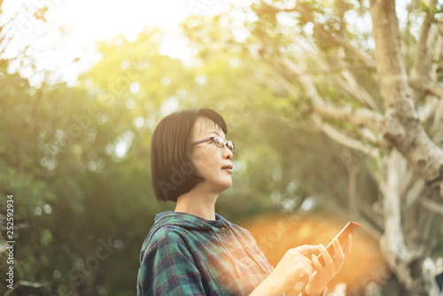 Asian mature woman using cellphone photo