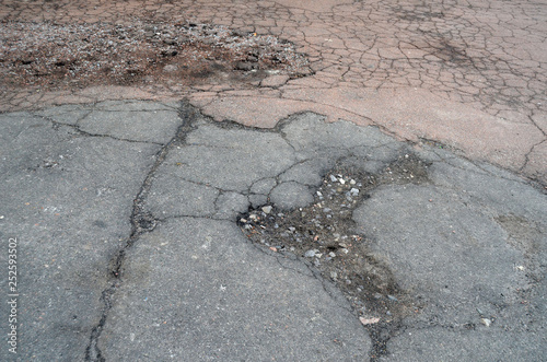 Poor condition of the road surface. Winter season. Hole in the asphalt, risk of movement by car, bad asphalt, dangerous road, potholes in asphalt.  Kiev,Ukraine