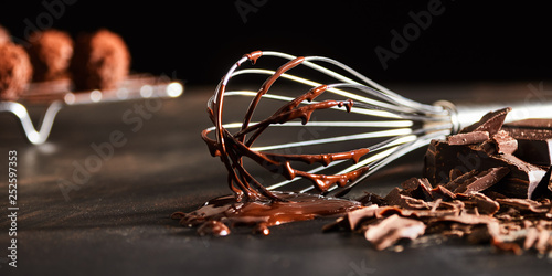 Old metal whisk coated in melted chocolate photo