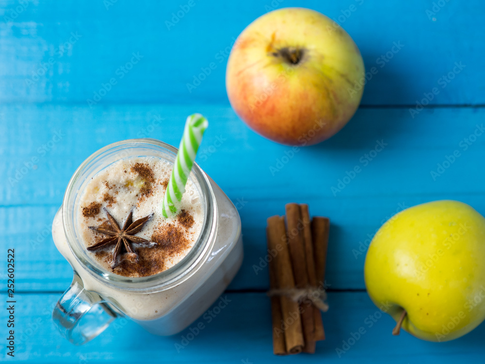 Healthy Apple smoothie with milk and cinnamon on a blue wooden table