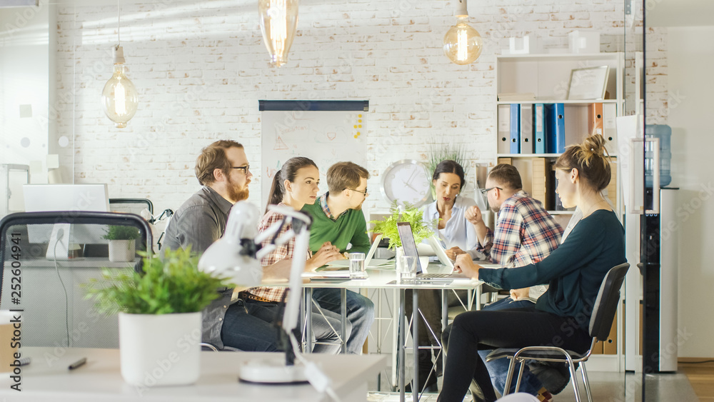 Seven Stylish People Having Planning Business Session Sitting at Big Table in their Bright Modern Creative Office. Seven Stylish People Having Planning Business Session Sitting at Big Table in their Bright Modern Creative Office.