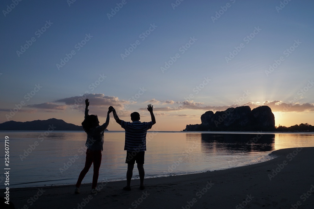 Fototapeta premium couple walking on the beach at sunset