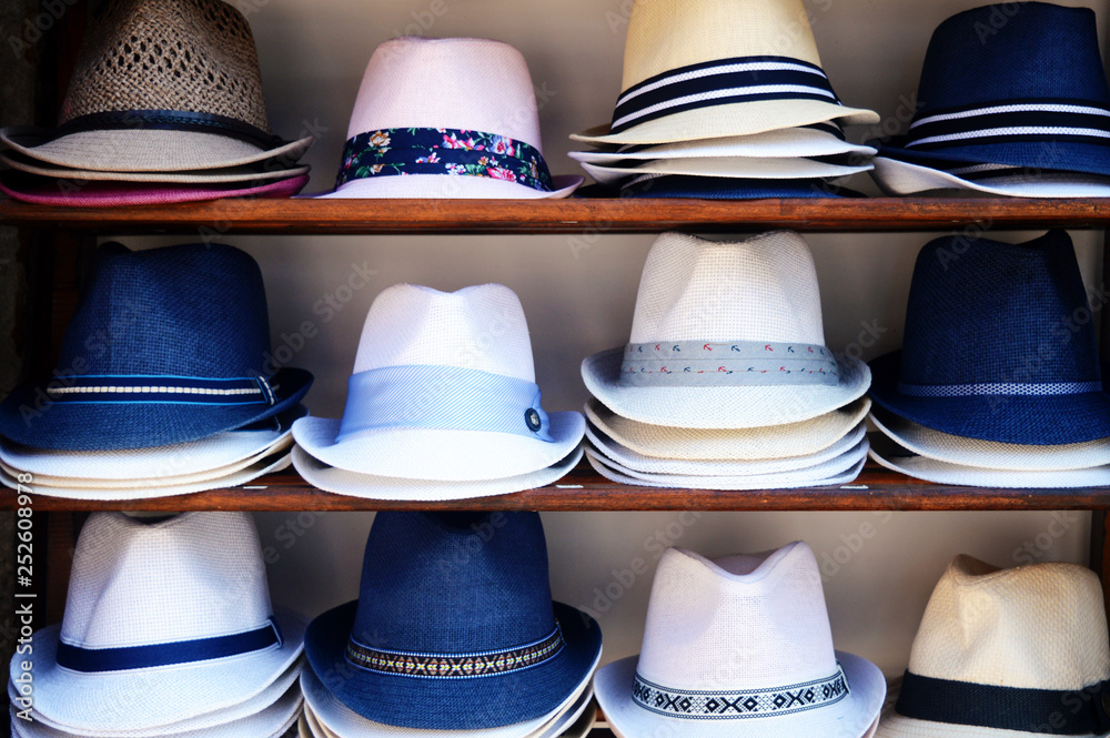 A collection of colored summer hats for sale in the tourist market.