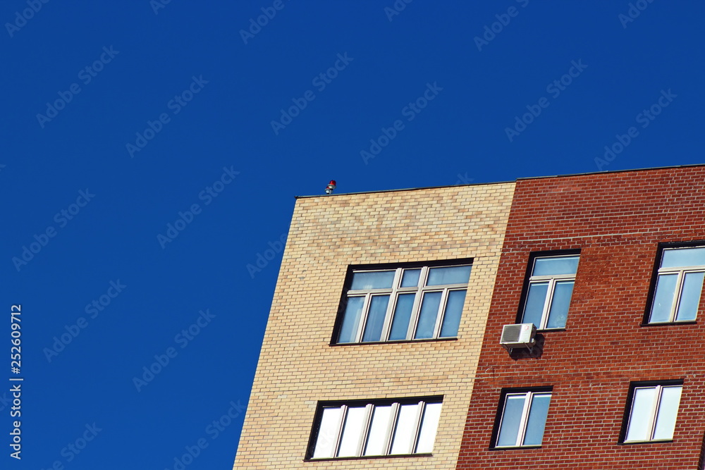 Modern brick office building on a background of clear blue sky.