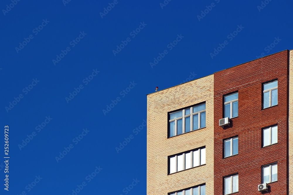 Modern brick office building on a background of clear blue sky.