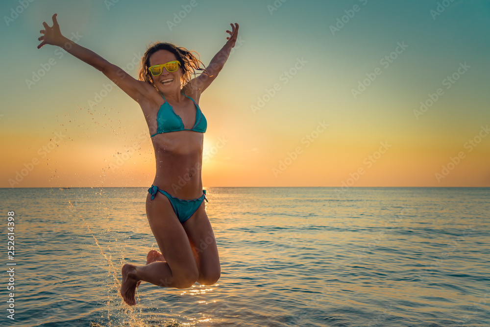 Fototapeta premium Happy woman jumping in the sea