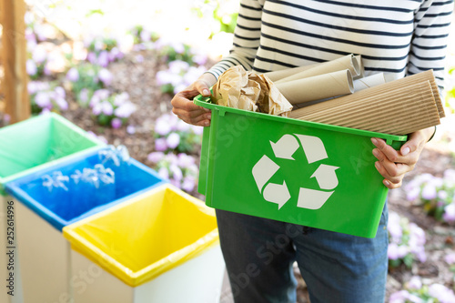 Cropped view of eco friendly woman holding green recycling box with paper waste