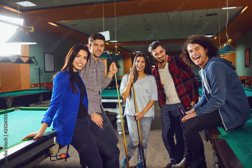 Group of friends laughing in the billiard club.