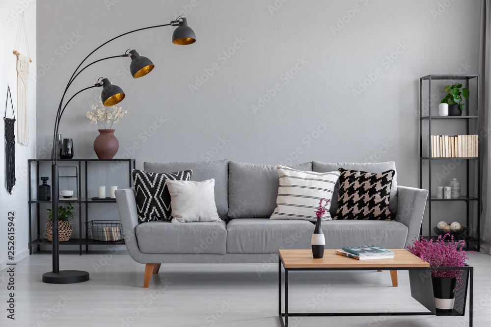 Obraz premium Real photo of a modern living room interior with a couch, patterned pillows and lamp