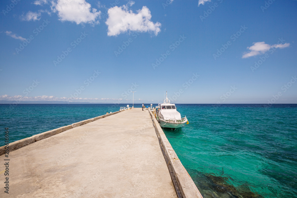 Fast ferry landing at the pier in a crystal clear sea water with blue and turquoise colors