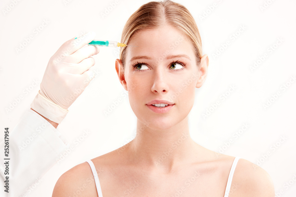 Close-up portrait of young woman having botox treatment