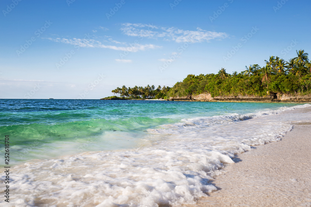 an exotic white beach with blue and turquoise water and white sand in a tranquil relaxing scene