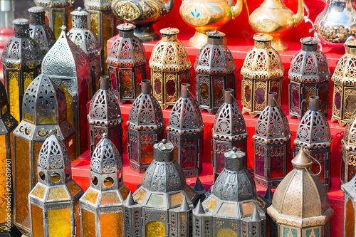 row of shiny traditional coffee pots and lamp photo