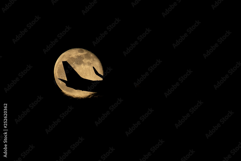 Naklejka premium Aircraft passing the supermoon.