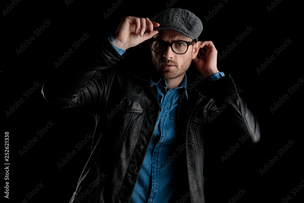 Obraz premium frown man with eyeglasses adjusting his cap