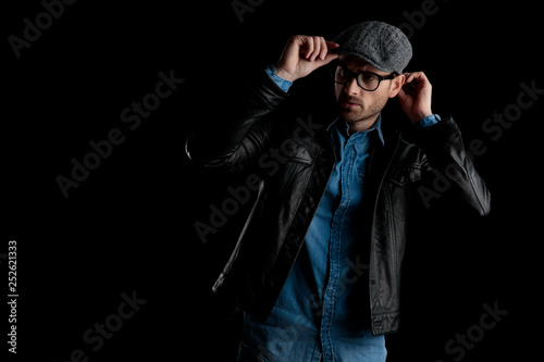 frown man with eyeglasses adjusting his cap with both hands