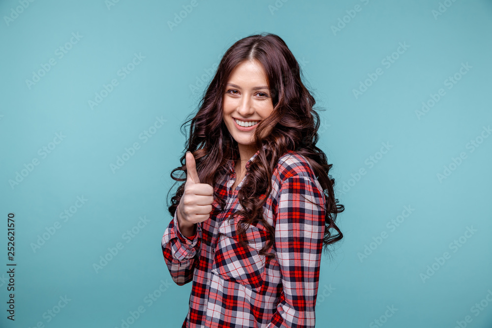 Fototapeta premium Pretty girl showing thumb isolated over the blue background