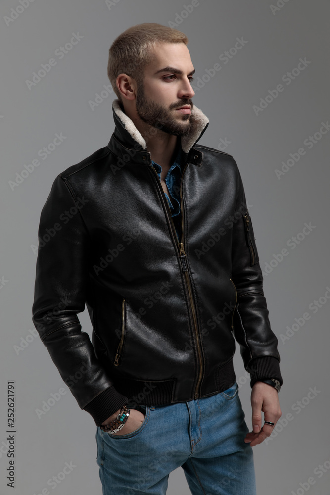 blonde guy in blue jeans and leather jacket looking away blonde guy in blue jeans and leather jacket looking away