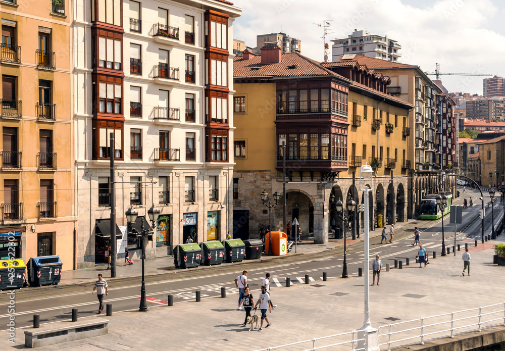Bilbao, Spain-September, 2018. Street of a city with people walking in them in a sunny day. Describe the ciry life