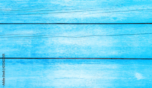 Old weathered wooden plank painted in blue color. Light blue plank texture of wood table. Trendy pastel coloured background.