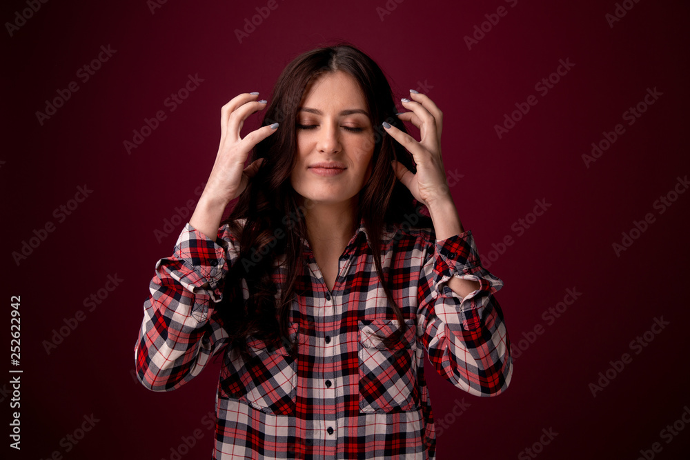 Angry woman feeling bad and has a headahce. Picture isolated over the dark pink background