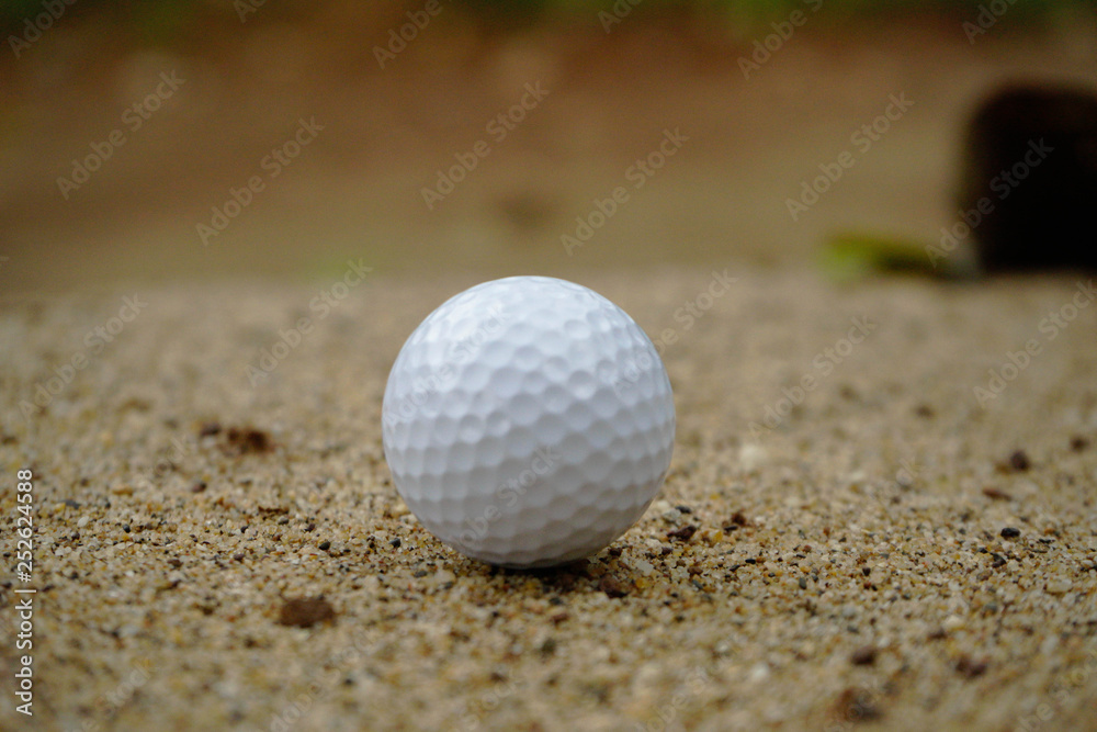 Golf ball on sand bunker in beautiful golf course at sunset background. Golf ball on green in golf course at Thailand Golf ball on sand bunker in beautiful golf course at sunset background. Golf ball on green in golf course at Thailand