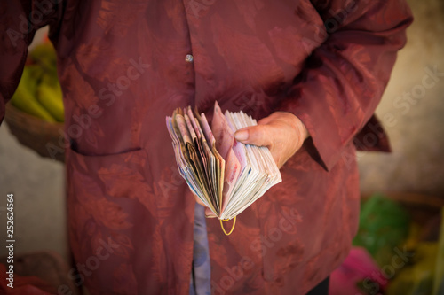 closeup of elderly hand holding purse with money photo