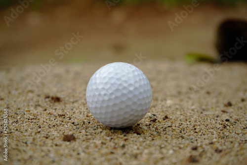 Golf ball on sand bunker in beautiful golf course at sunset background. Golf ball on green in golf course at Thailand