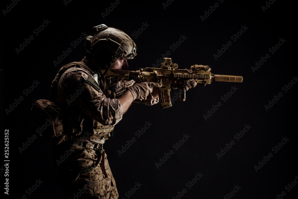 Special forces United States soldier or private military contractor holding rifle. Image on a black background. war, army and people concept Special forces United States soldier or private military contractor holding rifle. Image on a black background. war, army and people concept