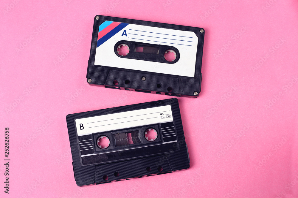 group of two audio retro vintage cassette tape 80s style on pink background