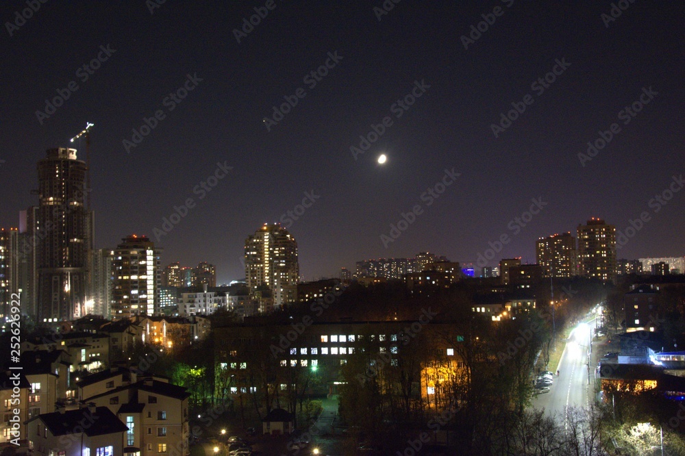 Fototapeta premium Khimki, Russia, night city, buildings, park, trees, moon, moonlight, people, cars, dogrog, light, water, sky, construction crane, city, lights, cityscape, skyline, panorama, water, light, bridge, refl