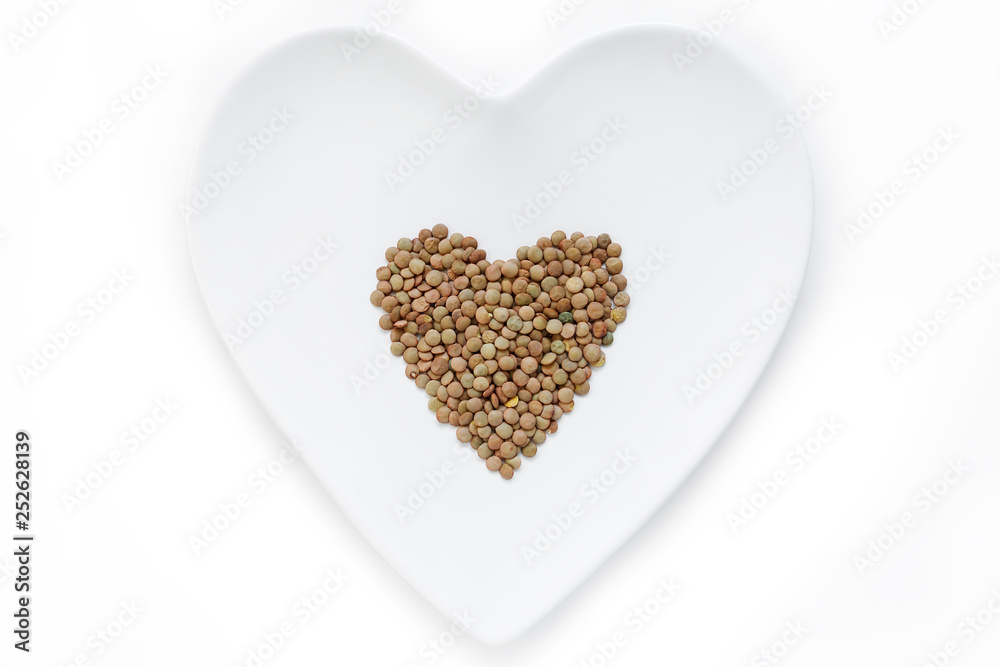 Lentils lie in the shape of a heart on a white plate Lentils lie in the shape of a heart on a white plate
